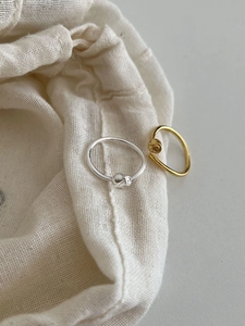 Detailed view of 925 sterling silver and gold rose rings on a soft cotton pouch
