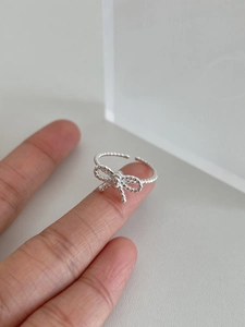 Close-up of S925 sterling silver bow ring with twisted rope texture on a finger