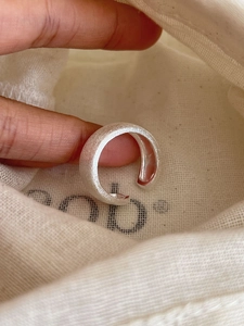 Detailed macro shot of an S925 sterling silver frosted ring on a natural linen fabric