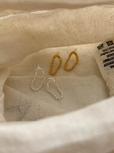 Gros plan de boucles d'oreilles minimalistes en chaîne V dorées et argentées