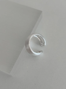Close-up of matte brushed silver adjustable ring on minimalist display stand