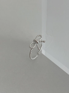 Detail of S925 sterling silver bow ring with twisted band and polished finish