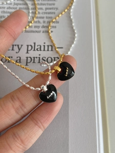 Detail of S925 silver Luck black heart pendants on gold and silver beaded chains