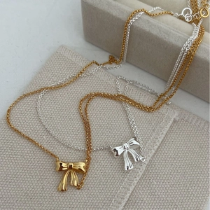 Elegant sterling silver bow pendant necklace in gold and silver finishes for women