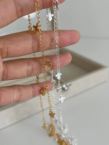 Detailed close-up of gold and silver cross pendant necklaces with lobster clasp and chain