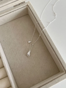 Detail of 925 sterling silver chain with a palm pendant and a sparkling zircon stone