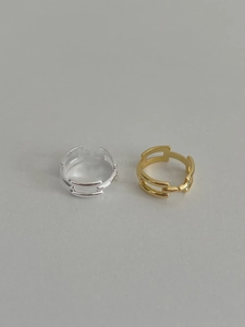 Detail view of adjustable geometric link rings in gold and silver plated metal