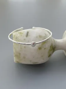 Close-up of S925 sterling silver hammered cuff bracelet with a smooth round bead detail