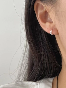 Détail d'une boucle d'oreille créole en argent S925 avec texture chaîne torsadée