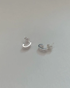Dettaglio di orecchini a C in argento sterling 925 con scintillanti pietre di zircone