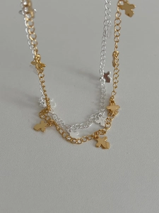 Detailed macro shot of silver and gold two-tone chain with mini cross charms