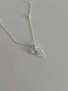 Detail showing 925 silver necklace with hand pendant and sparkling zircon stone