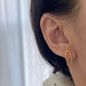 Boucles d'oreilles minimalistes en argent S925 dorées en V portées par un mannequin