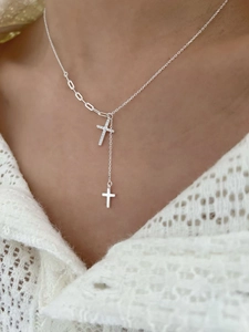 Dettaglio macro di una collana a Y in argento 925 con ciondoli a croce in zirconi