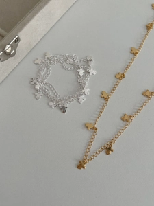 Detailed view of silver and gold O-chain bracelets featuring small 3D teddy bear pendants
