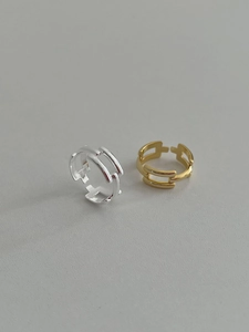 Detailed view of geometric hollow rings in gold and silver finish with parallel layers