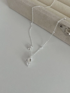 Close-up of 925 silver necklace with palm pendant and zircon on velvet jewelry box