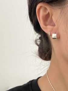 Detail shot of a silver S925 sterling silver hoop earring with star zircon on a model
