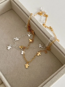 Close-up of gold and silver minimalist necklaces featuring multiple tiny bird pendants