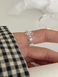 Close-up of S925 sterling silver ring with small hollow flowers and sparkling crystals