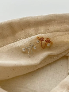 Gros plan de boucles d'oreilles nœud élégantes en argent 925 et or avec perles