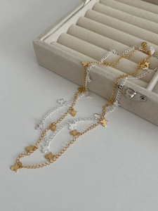 Detail showing S925 hallmark on gold and silver cross necklaces on grey velvet box