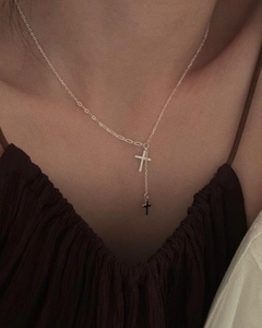 Dettaglio di una collana a Y in argento 925 con ciondoli a croce impreziositi da diamanti