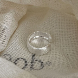 Minimalist S925 sterling silver matte brushed open ring on a textured fabric background