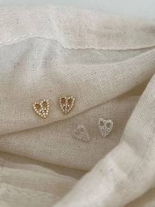 Detail view of heart-shaped 925 silver earrings with sparkling cubic zirconia on fabric