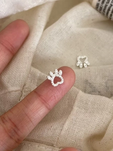Detailed macro view of S925 silver cat paw earrings with tiny heart cutout and zircon stones