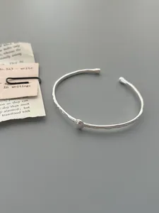 Close-up of S925 sterling silver hammered cuff bracelet with a minimalist bead accent