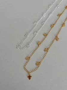 Detail of gold and silver cross charm necklaces with textured pendant design on flat surface