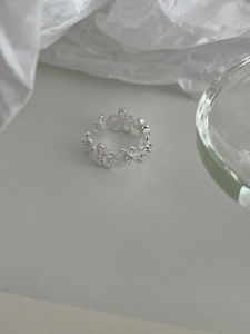 Macro detail of S925 sterling silver floral ring with intricate hollow flower engravings