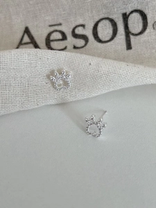 Detail of S925 silver cat paw earrings with heart cutout and sparkling zircon inlay