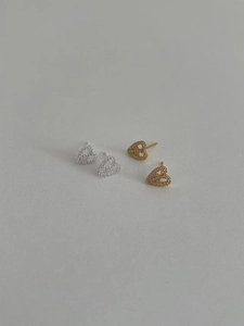 Close-up of gold and silver heart stud earrings with sparkling pave-set cubic zirconia
