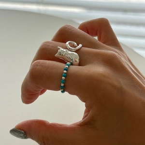 Minimalist 925 sterling silver cat ring with light blue beads on a model's finger