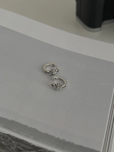 Macro shot of S925 sterling silver hoop earrings with vintage cross floral relief