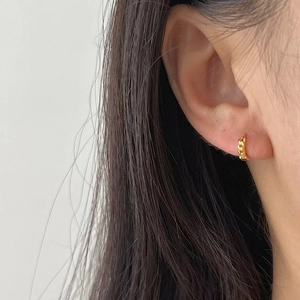 Boucles d'oreilles créoles torsadées en argent 925 plaqué or portées par mannequin