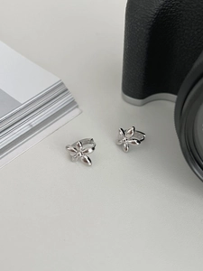 Detailed view of silver flower hoop earrings with minimalist five-petal metal design
