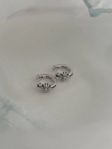 Macro shot of 925 sterling silver hoop earrings with vintage floral relief and S925 hallmark