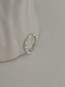 Macro shot of silver adjustable ring with embossed texture and micro-inlaid stones