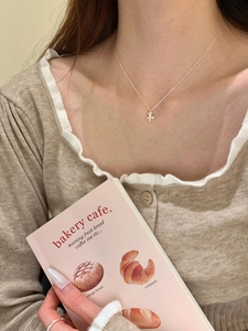 Close-up of S925 silver butterfly pendant necklace worn by a model in a warm setting