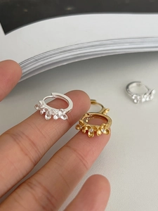 Vue rapprochée de créoles en argent 925 avec trois fleurs serties de zircons