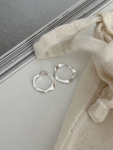 Détails de boucles d'oreilles anneaux Mobius en argent 925 sur fond blanc minimaliste
