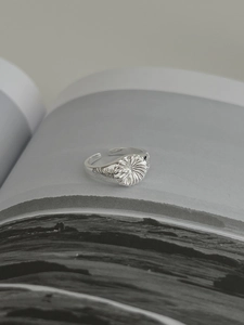 Macro shot of S925 silver sunburst relief ring with vintage feather pattern on open band