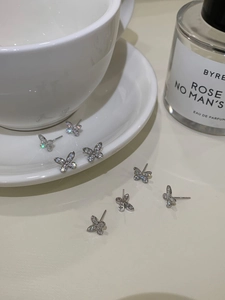 Detailed view of silver butterfly stud earrings with sparkling crystals in a luxury set