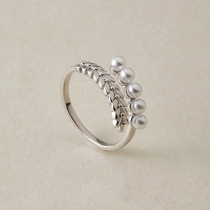 Macro shot of S925 silver ring featuring wheat ear patterns and five white pearls