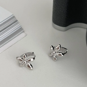 Polished silver five-petal flower huggie earrings with a modern minimalist metal design