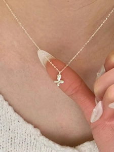 Detailed close-up of a delicate S925 silver butterfly pendant necklace on a model's finger