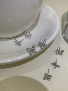 Close-up of 925 silver butterfly stud earrings with sparkling pavé cubic zirconia